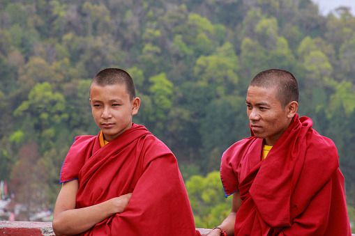 Sikkim, India, April 6 2015 - Boys monks in red clothes in a Buddhist monastery against the background of nature.