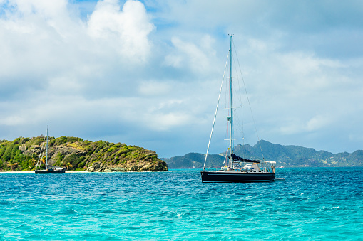 Turquoise sea and black yacht anchored at Tobago Cays, Saint Vincent and the Grenadines, Caribbean sea