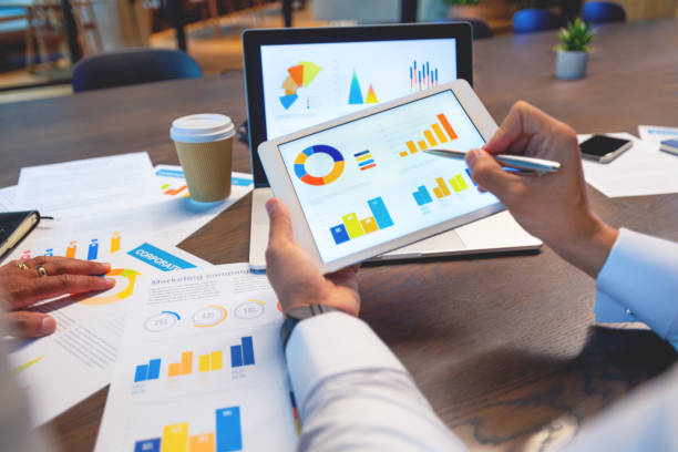 istock Two business men working on a laptop and digital tablet with financial charts, graphs and data in the office 1517597458