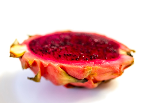 Closeup half of the red Dragon fruit, white background with copy space, full frame horizontal composition
