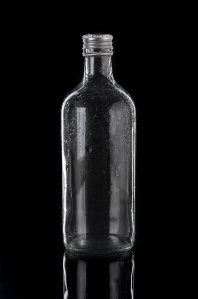 istock Empty glass bottle close up on a black background 1517628659