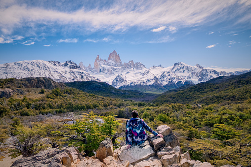 Young man sitting on the point view overlooking Mount Fitz Roy