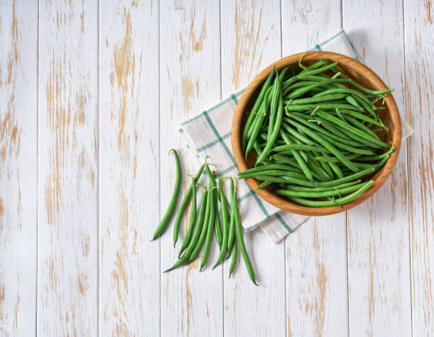 istock fresh green beans in a bowl on a white wooden table, top view. 1517671870