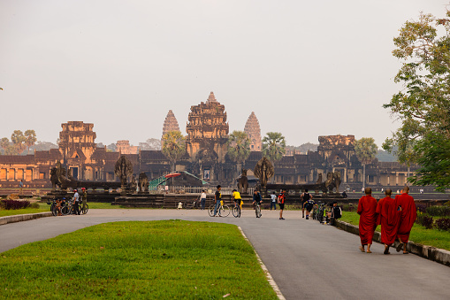 Monks and tourists in front of the West Entrance of Angkor Wat in Siem Reap, Cambodia
