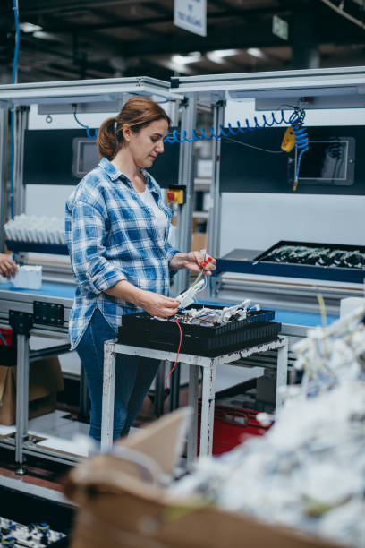 istock Female technician working with manufacturing equipment in a factory 1517776792