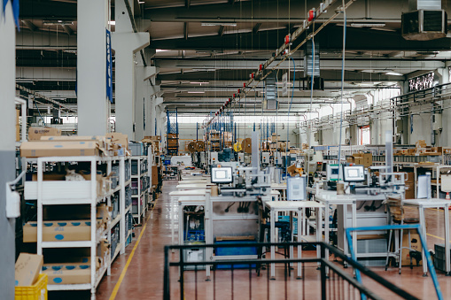 High angle aerial view of an empty electronic industrial building with injection molding CNC machine parts putting, checking and testing industrial equipment cables for serving the white goods and electric electronics sectors in modern large wire and cable manufacturing plant factory warehouse