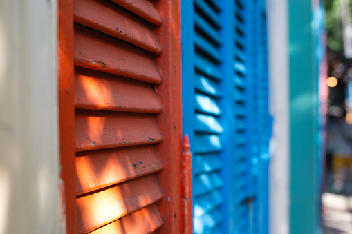 Hermosas persianas rojas y azules de colores brillantes y auténticas de casas antiguas photo