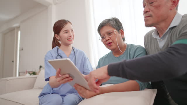 Senior couples patients talk to caring female doctors and physician caregivers at nursing homes in the hospital. Medical staff explaining well-being get support and Medicare services at medical checkup visits. Concepts of health insurance, retirement.
