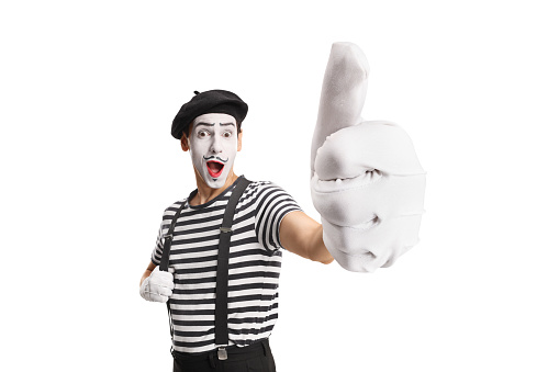Cheerful mime gesturing a thumb up sign isolated on white background