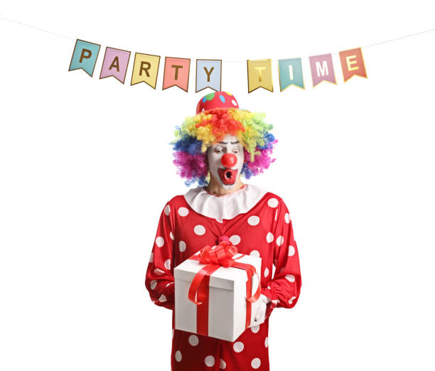 istock Clown holding a present box under flags with text party time 1518024751