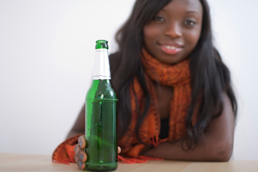 A young african woman with a beer bottle.