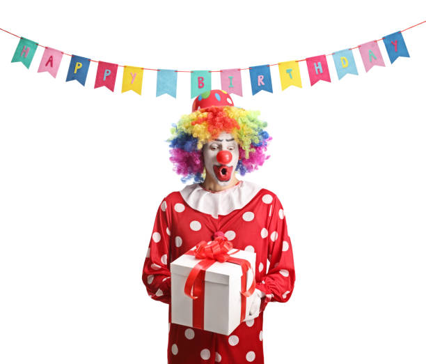 istock Surprised clown in a red costume holding a present box 1518058002