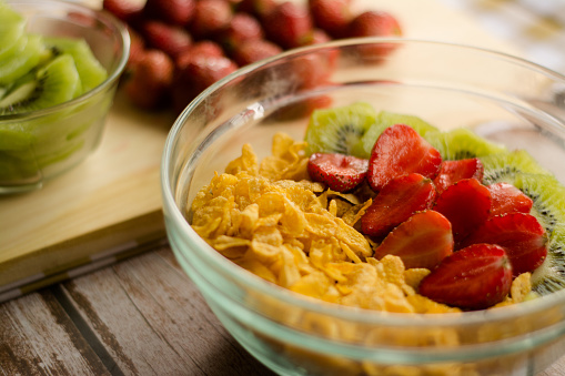 Image of mixed Corn flakes and Fruits (Strawberries & Kiwis) for breakfast.