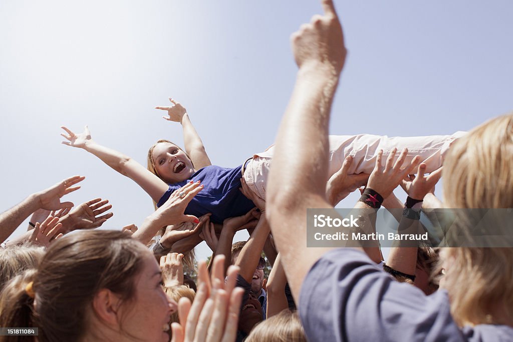 Enthusiastic woman crowd surfing  Crowd Surfing Stock Photo