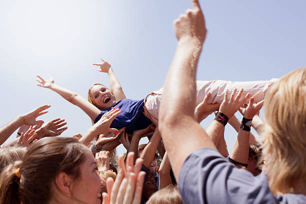 Enthusiastic woman crowd surfing  exhilaration stock pictures, royalty-free photos & images