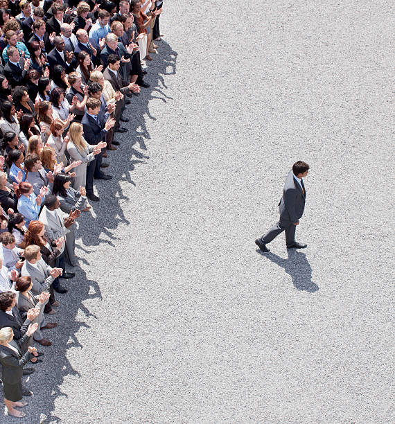 Businessman walking away from clapping crowd  people walking away stock pictures, royalty-free photos & images