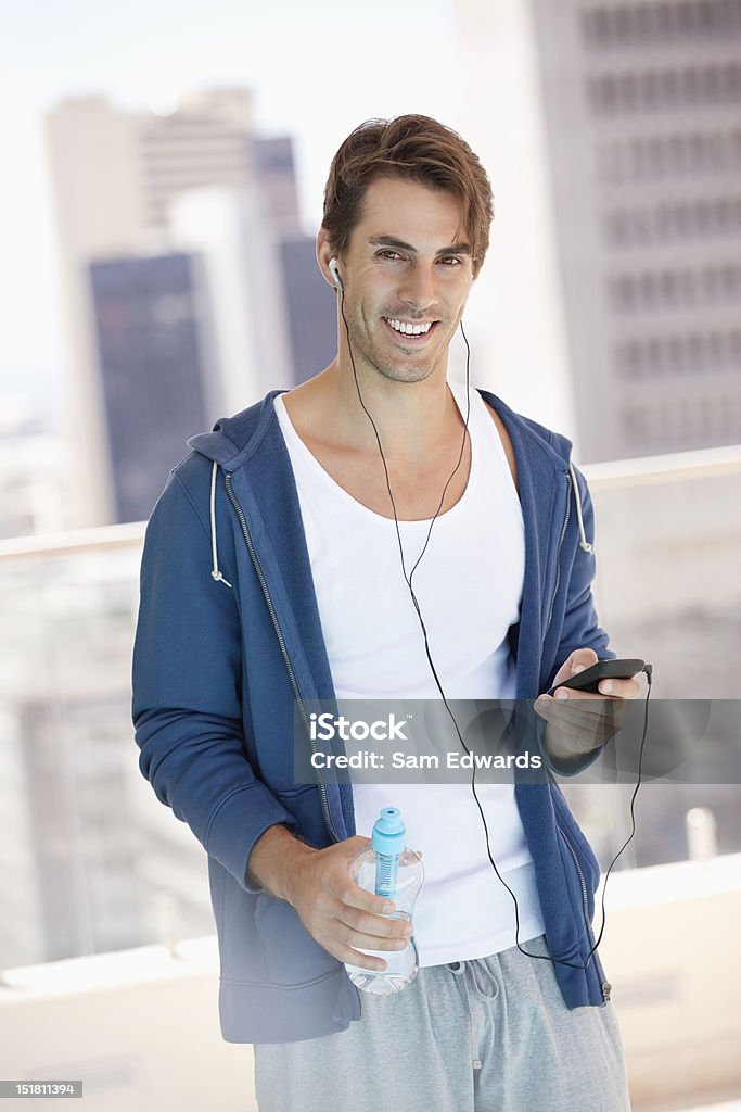 Porträt eines lächelnden Mann hält eine Flasche Wasser und Zuhören - Lizenzfrei Europäischer Abstammung Stock-Foto