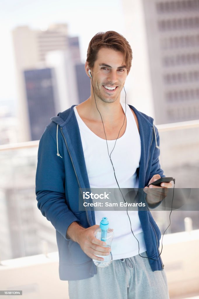 Retrato de homem sorridente segurando uma garrafa de água e ouvir - Royalty-free De aparência caucasiana Foto de stock