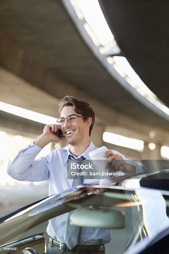 Sorridente Empresário falando no telefone celular e segurando uma xícara de café " - Foto de stock de Carro royalty-free