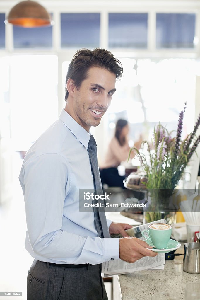Retrato de la sonriente hombre de negocios con un café y periódico en el Café - Foto de stock de 20-24 años libre de derechos