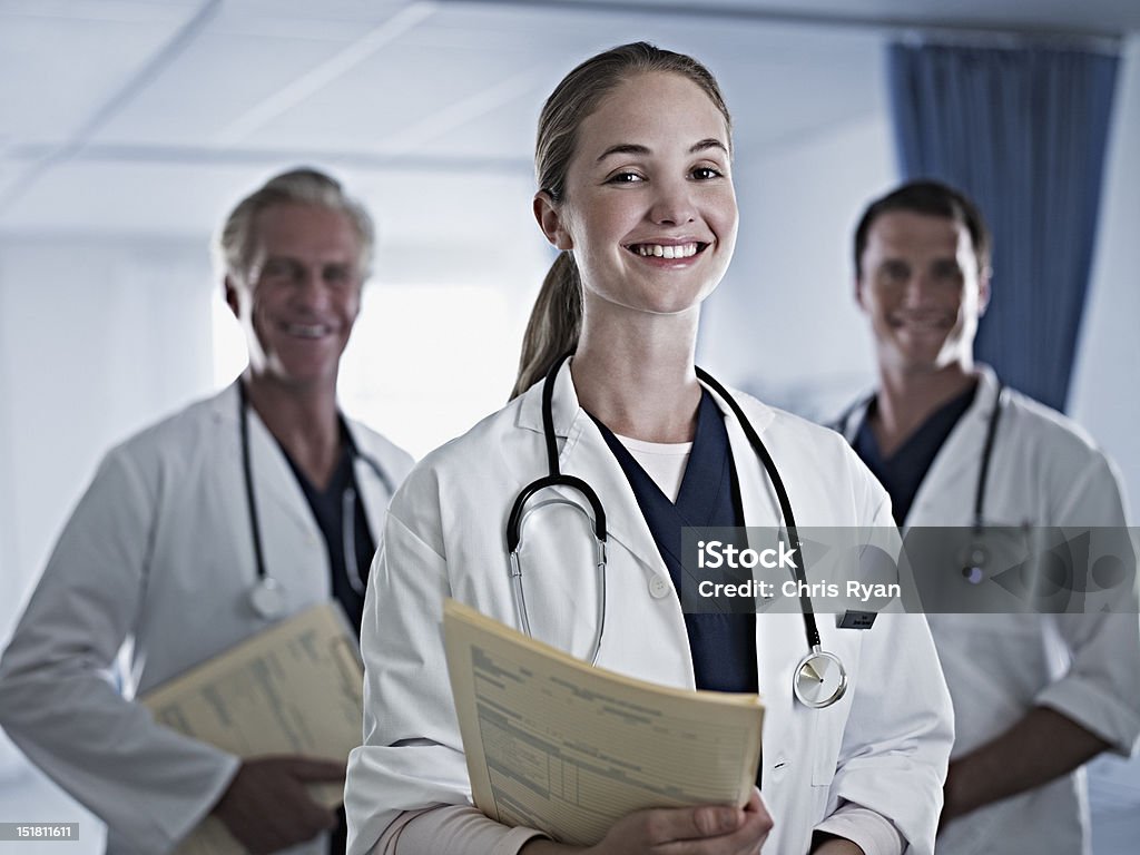 Ritratto di un sorridente medici con Documenti medici in ospedale - Foto stock royalty-free di 25-29 anni