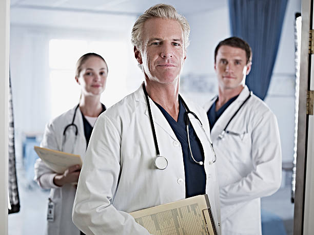 porträt von zuversichtlich ärzte im krankenhaus zimmer - horizontal female with group of males posing looking at camera stock-fotos und bilder