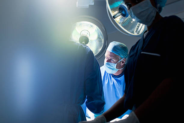 funcionamiento cirujanos de trabajo en la habitación - cirugía fotos fotografías e imágenes de stock