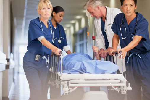 Médico y enfermeras wheeling paciente en mesa de ruedas de hospital corri de photo