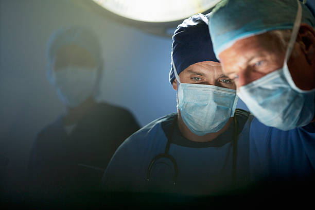 close up of focused surgeons working in operating room - 防護口罩 圖片 個照片及圖片檔
