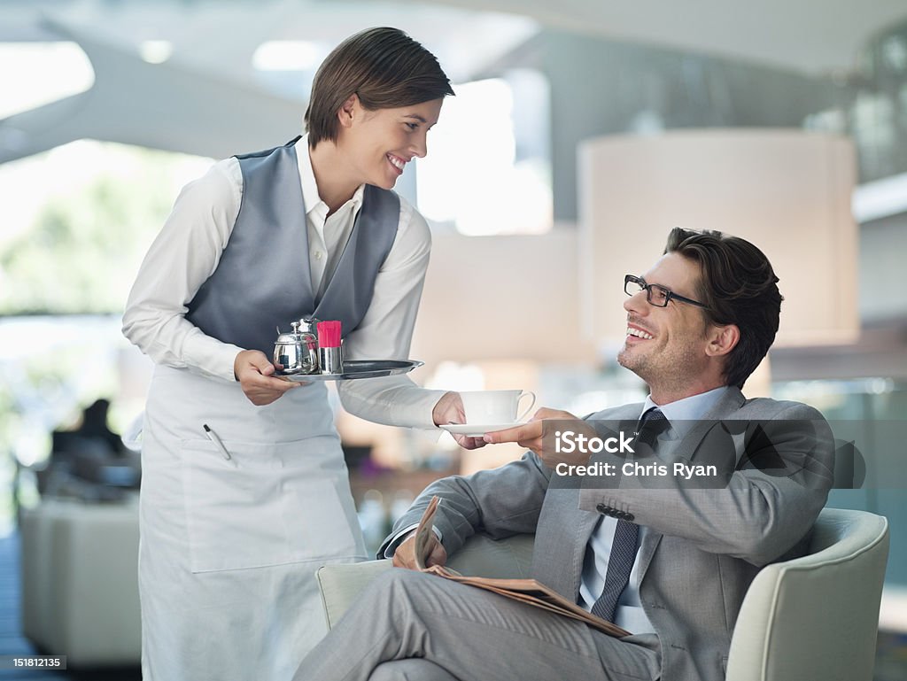 Serveuse servir Homme d'affaires d'une tasse de café dans le salon de l'hôtel - Photo de Hôtel libre de droits