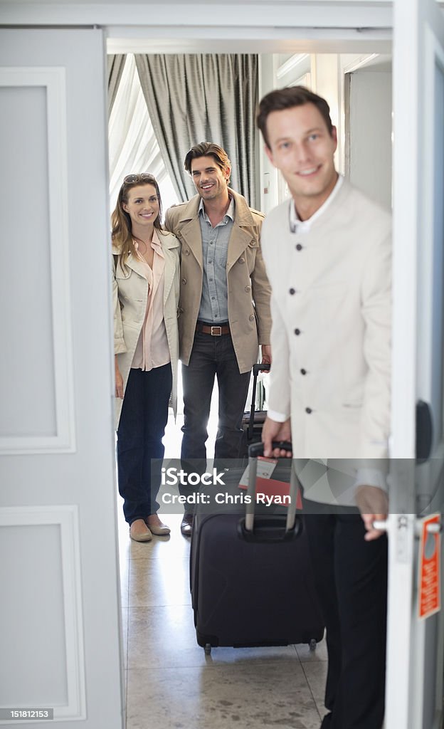 Portret bellman otwarcia drzwi z pokoju hotelowego Para - Zbiór zdjęć royalty-free (Pokój hotelowy)