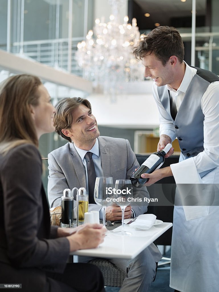 Sommelier presentar botella de vino de pareja en el restaurante - Foto de stock de Camarero libre de derechos
