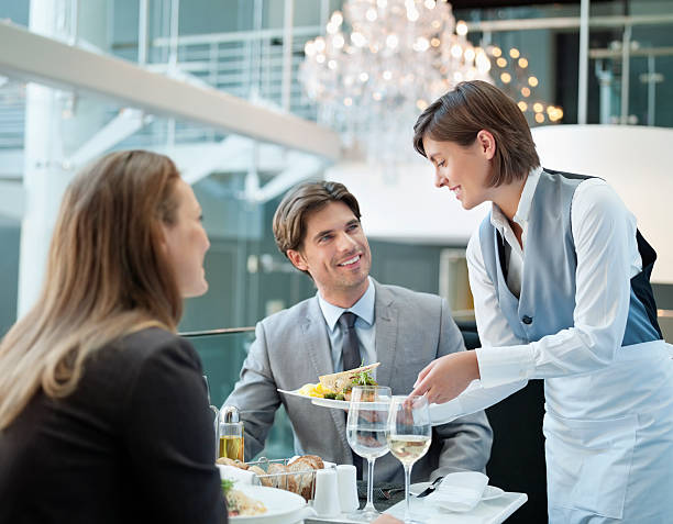 kellnerin serviert speisen für zwei personen im restaurant - dinner service stock-fotos und bilder