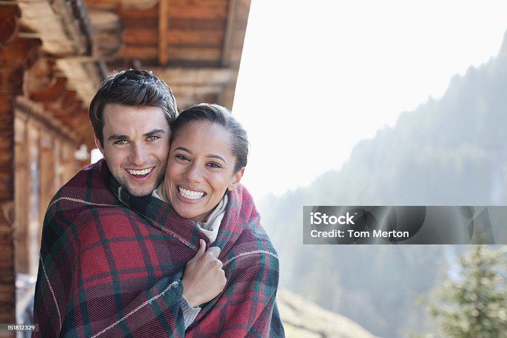 Портрет улыбающаяся пара Завёрнутый в одеяло на - Стоковые фото Зима роялти-фри