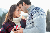 Smiling couple face to face with Christmas gift