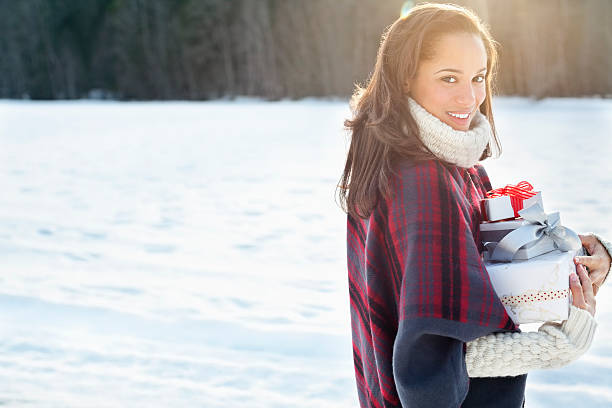 retrato de mujer sonriente llevar de navidad y regalos en la nieve - beautiful women gift christmas fotografías e imágenes de stock