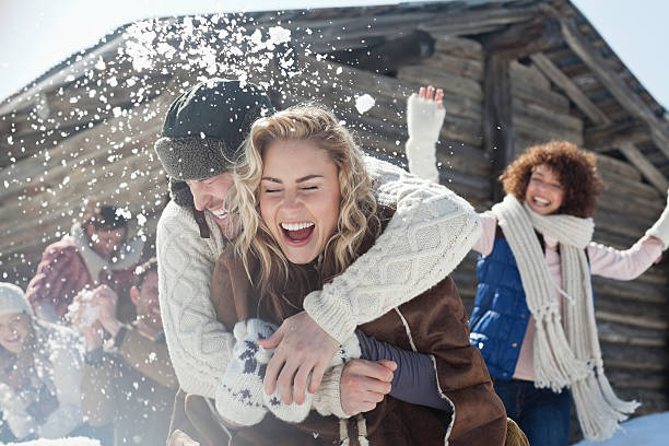 friends enjoying snowball fight - winter stockfoto's en -beelden