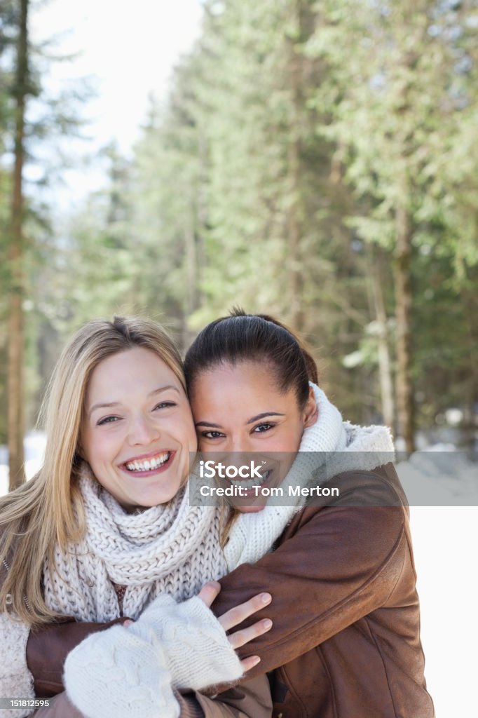 Portret uśmiechnięta znajomych objąć w snowy woods - Zbiór zdjęć royalty-free (25-29 lat)