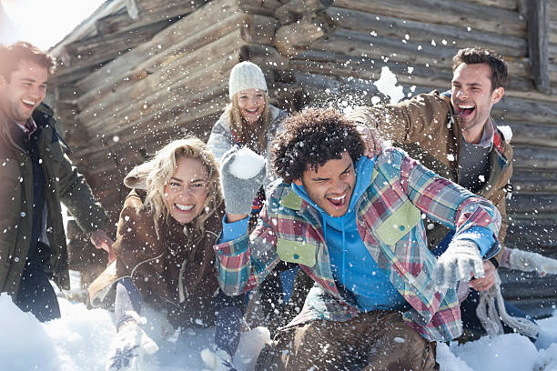 Friends enjoying snowball fight  log cabin photos stock pictures, royalty-free photos & images