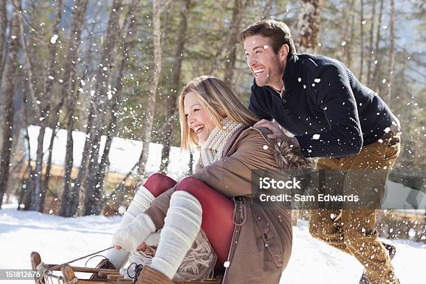 Sonriendo Par De Paseos En Trineo En La Nieve Foto de stock y más banco de imágenes de Invierno - Invierno, Trineo - Artículo recreativo, Felicidad