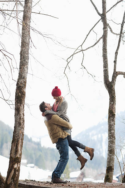 uomo sollevamento pesi donna nel bosco delle nevi - fun knit hat adult dating foto e immagini stock