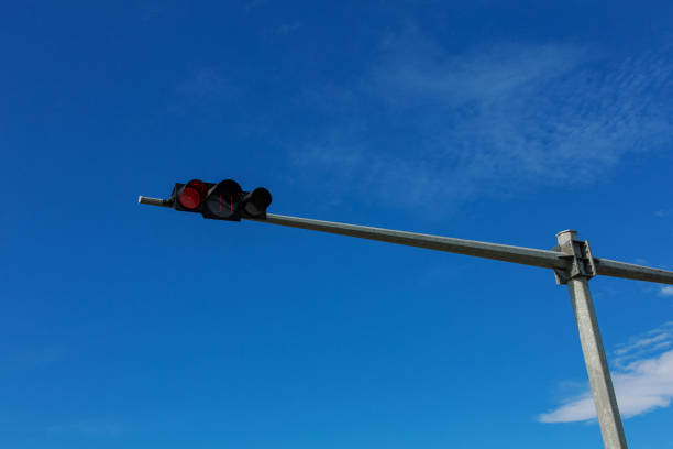 istock Traffic light pole at red light and blue sky 1518181179