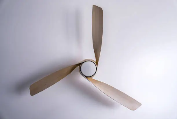 Modern wood ceiling fan isolated in the center of a white background