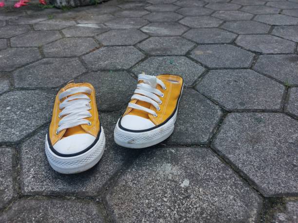 istock yellow sneakers with paving background 1518240019