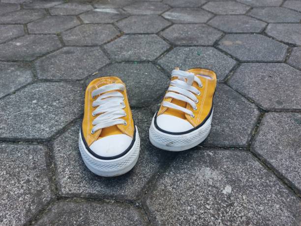 istock yellow sneakers with paving background 1518240312