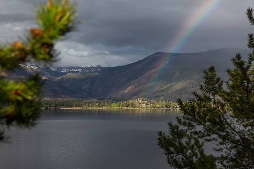 Rainbow over a mountain lake in the summer.