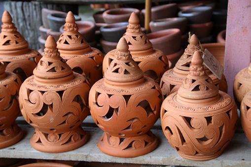 Group of native Thai retro style pottery clay in pot shape on wood plank for sale.