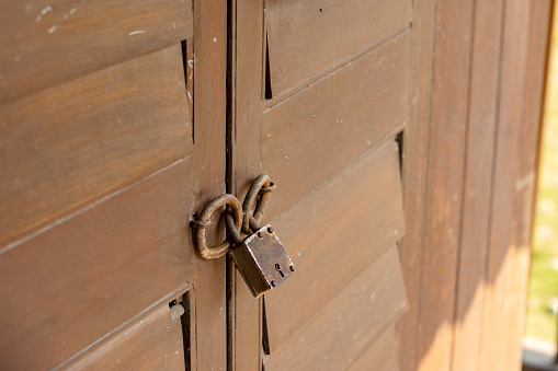 Vintage lock on a closed brown wooden door background, Closeup