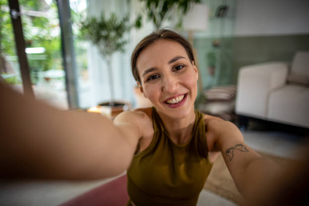 istock Young woman taking selfies while exercising at home 1518414839