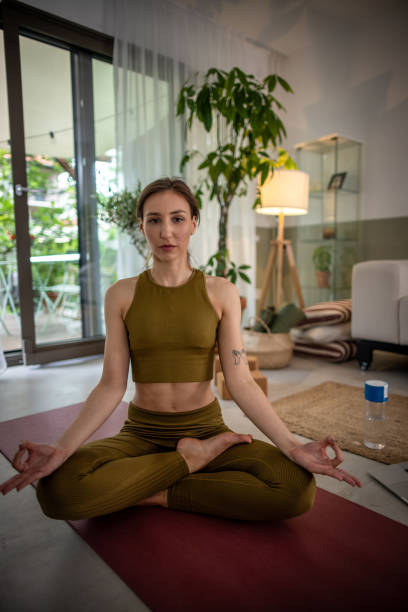 istock Young woman practicing yoga at home 1518431446